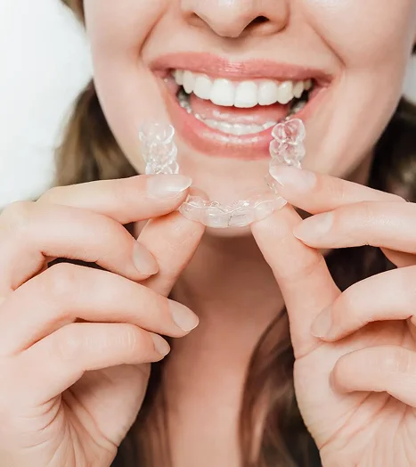 Woman inserting an Invisalign clear aligner
