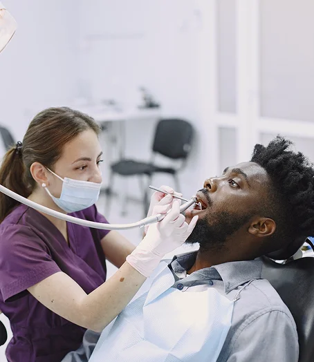 Young woman checking her new smile in a hand mirror at dentist