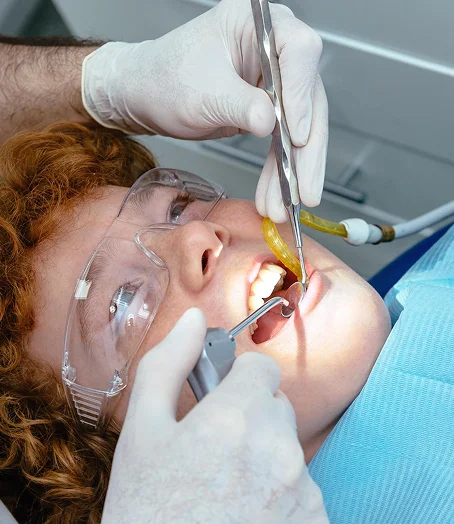 Dentist performing dental procedure on patient wearing protective glasses