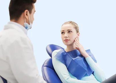 Dentist explaining tooth anatomy and treatment options using a dental model