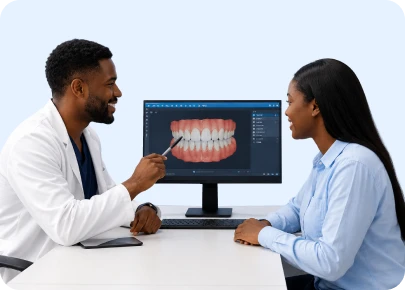 Dentist and patient reviewing a digital model of teeth on a computer screen